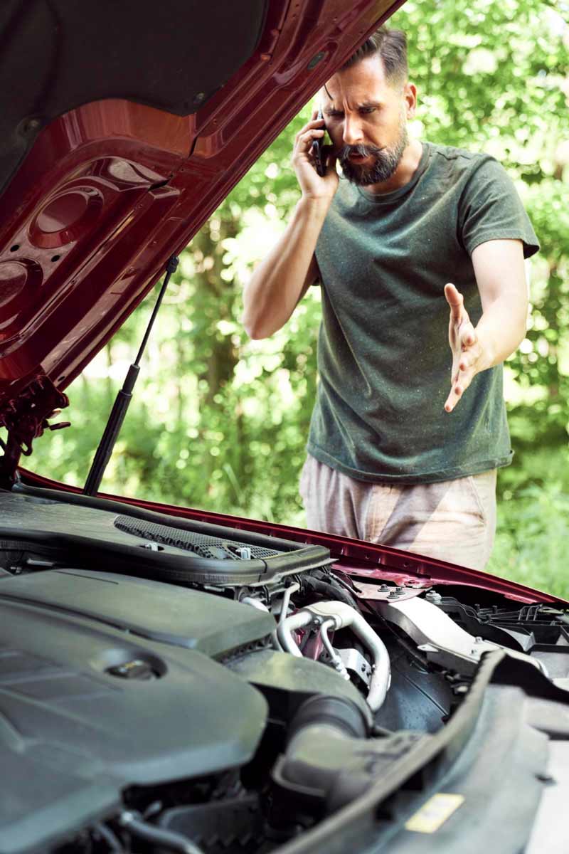 Junger Mann prüft Getriebeschaden bei Schrottauto Ankauf Neuwied